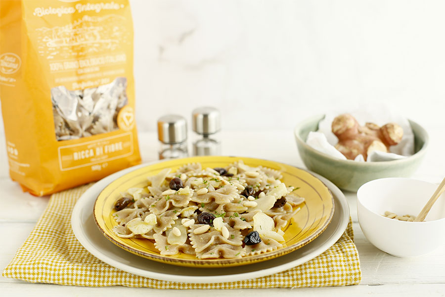 Farfalle with topinambur, taggiasche olives and pine nuts