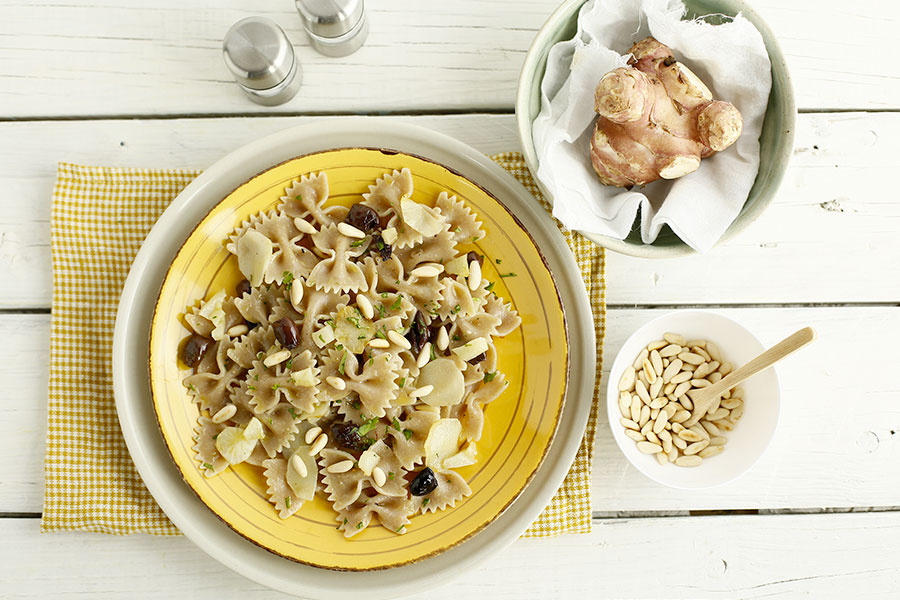 Farfalle with topinambur, taggiasche olives and pine nuts